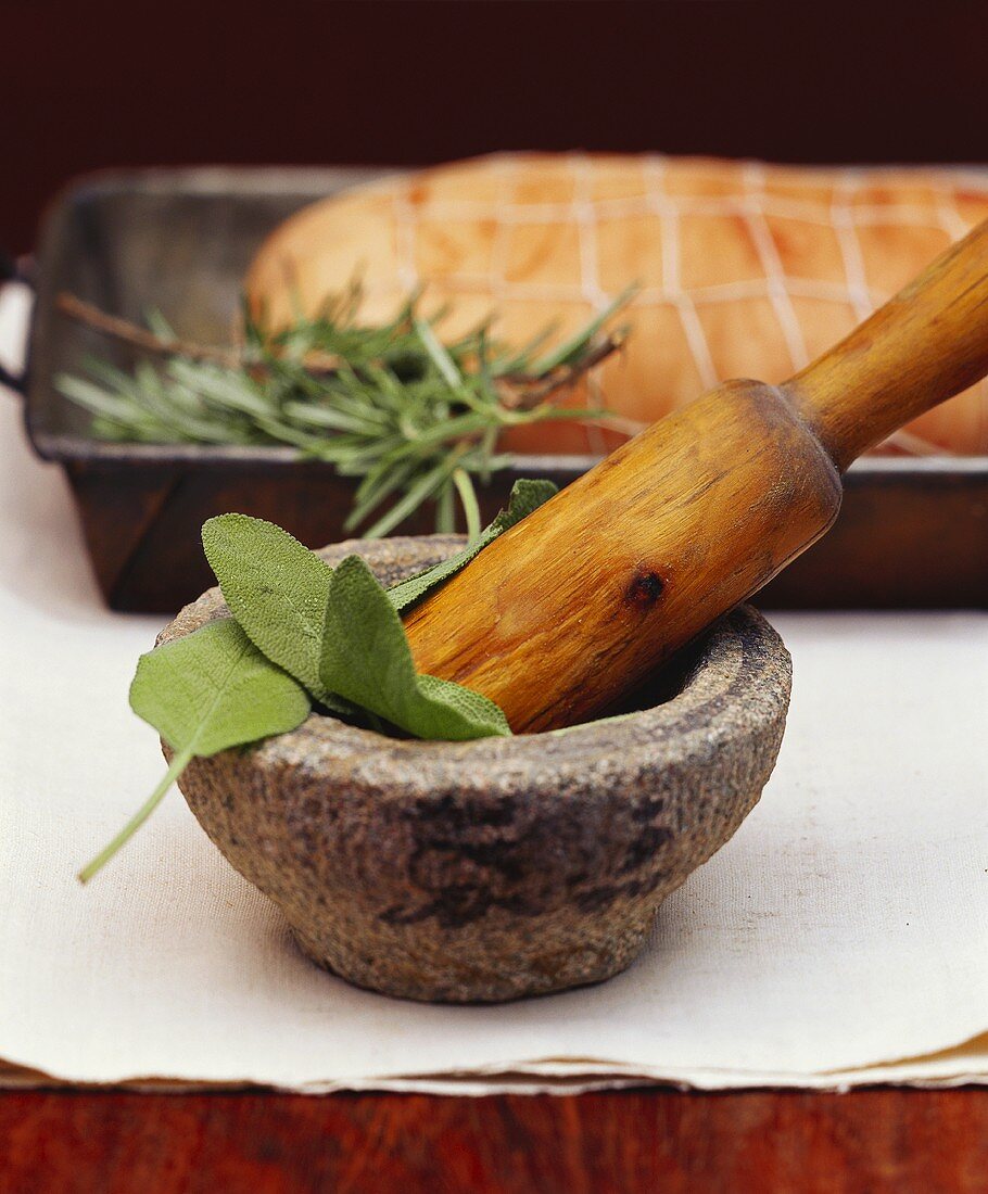 Mortar with sage leaves, rolled joint behind