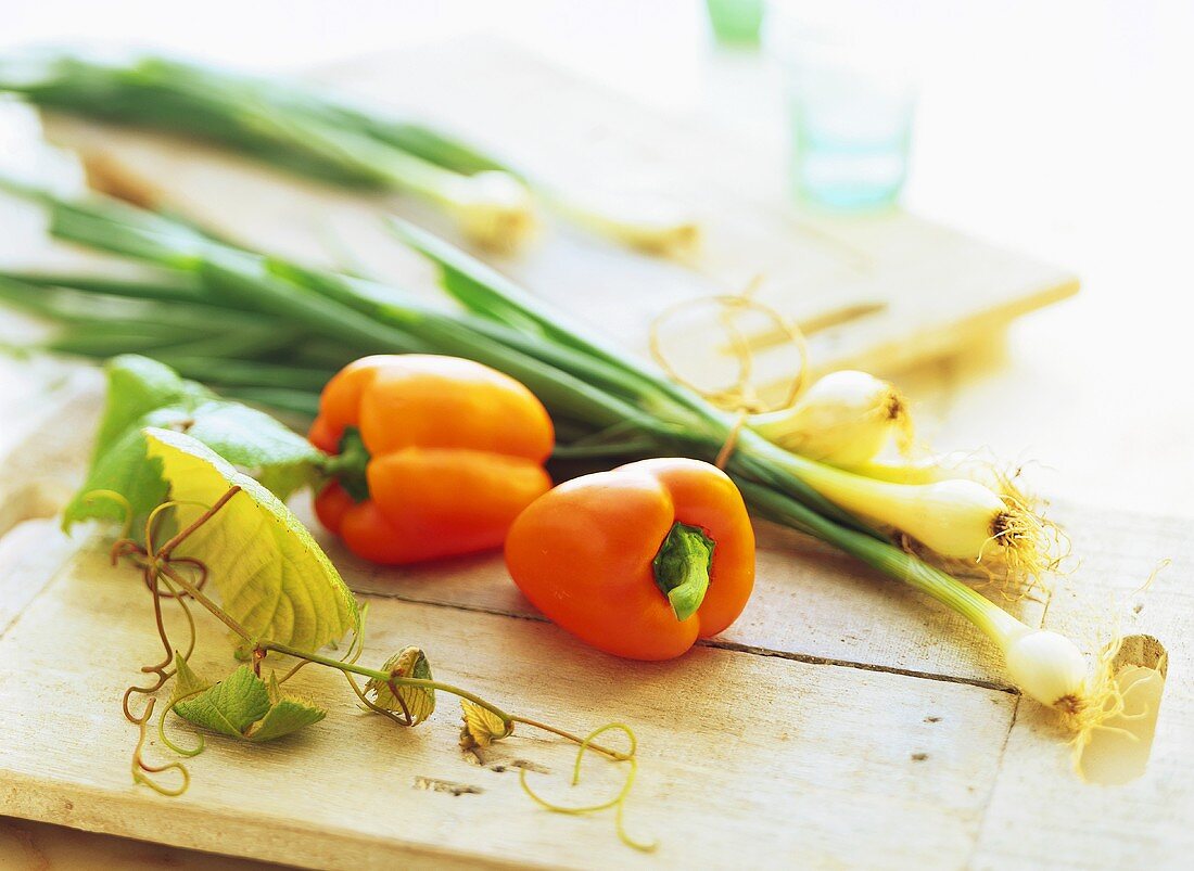 Orangefarbene Paprikaschoten und Frühlingszwiebel