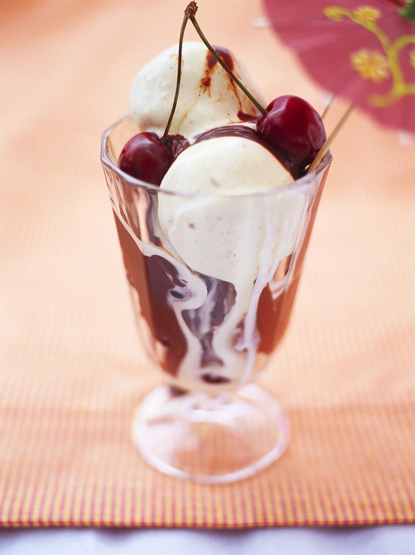 Vanilla ice cream with chocolate sauce and cherries