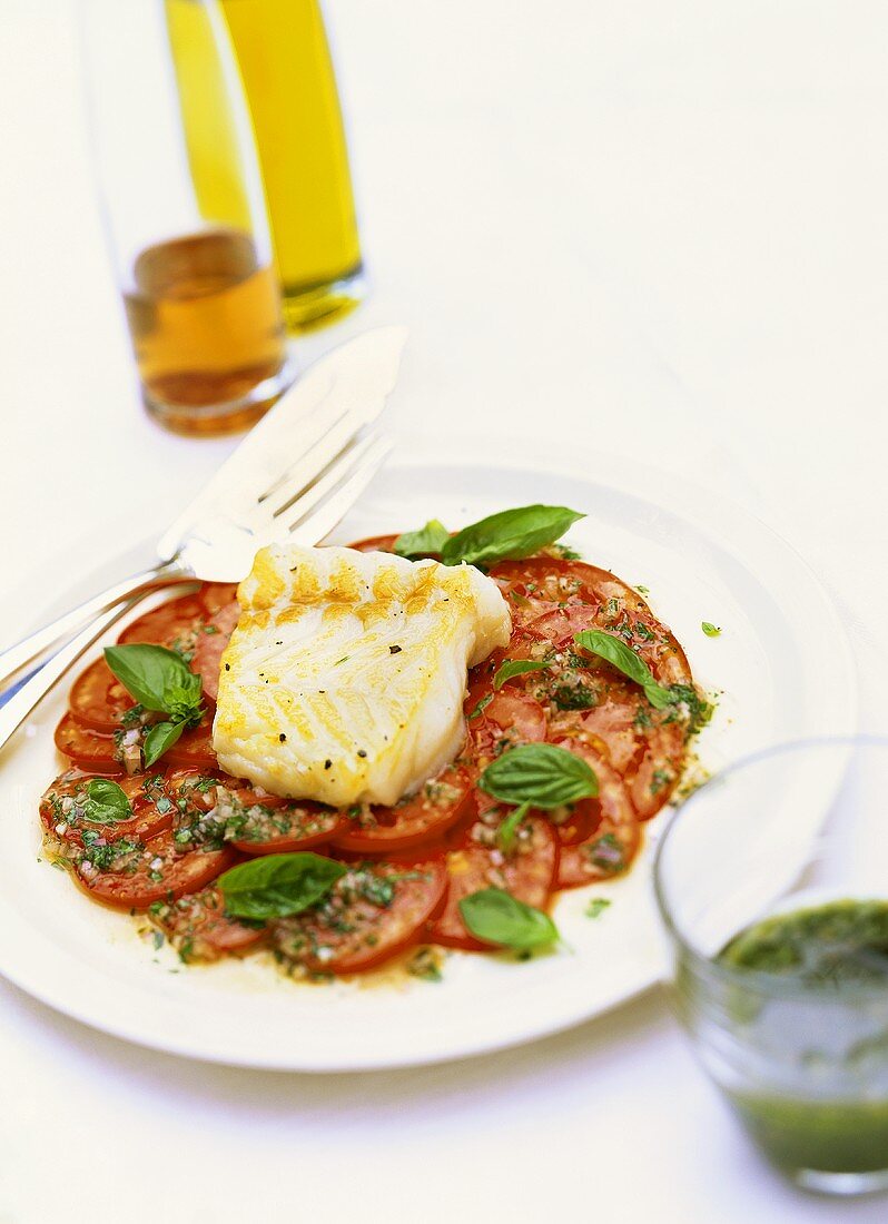 Fried cod on tomato carpaccio and pesto