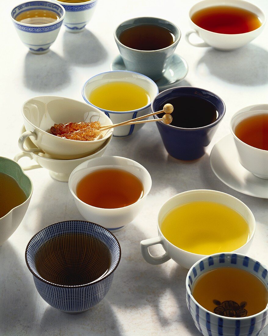 Verschiedene Tees in Schälchen und Tassen