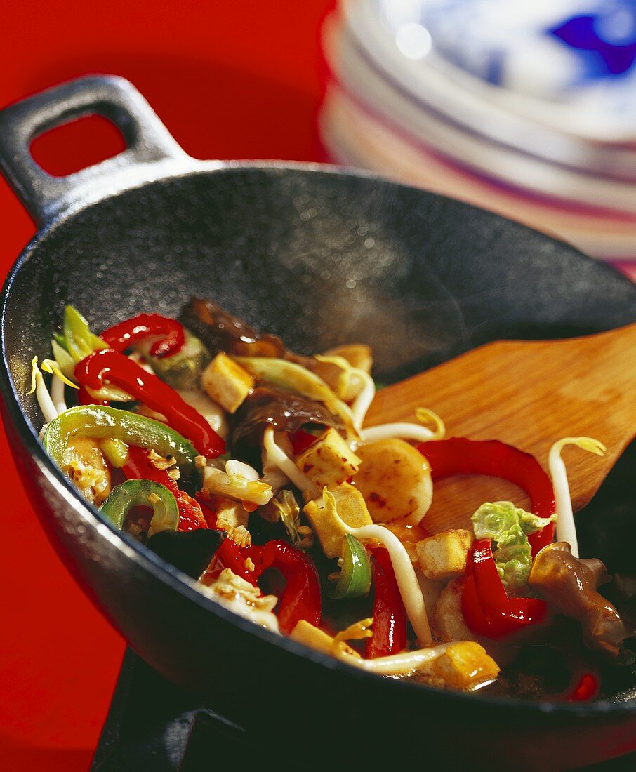 Vegetables with diced tofu in wok