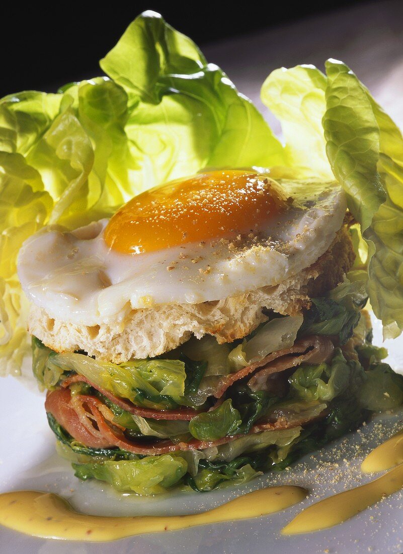 Steamed lettuce, bacon and fried egg on bread