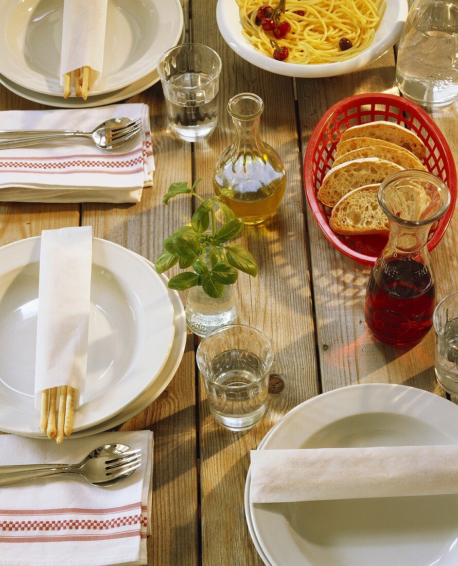 Gedeckter Holztisch mit Grissini und Pasta