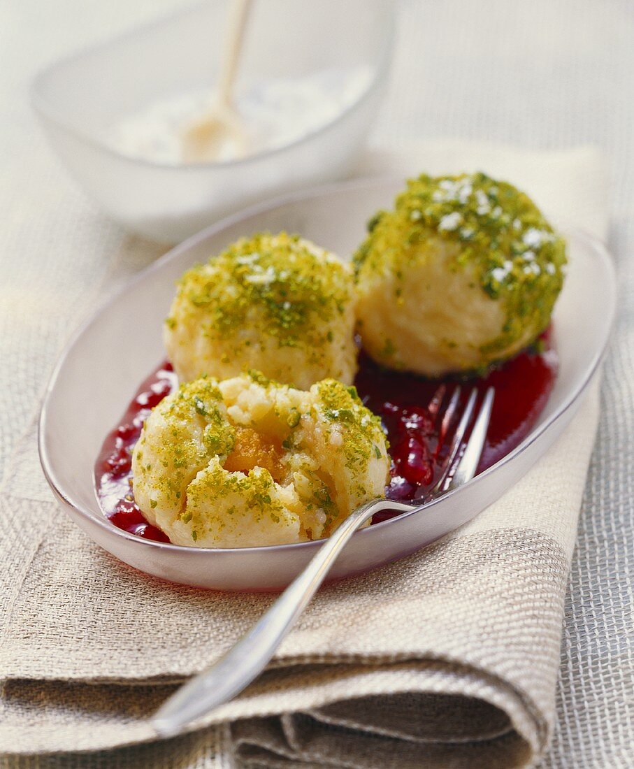 Apricot dumplings with pistachios on cranberry sauce