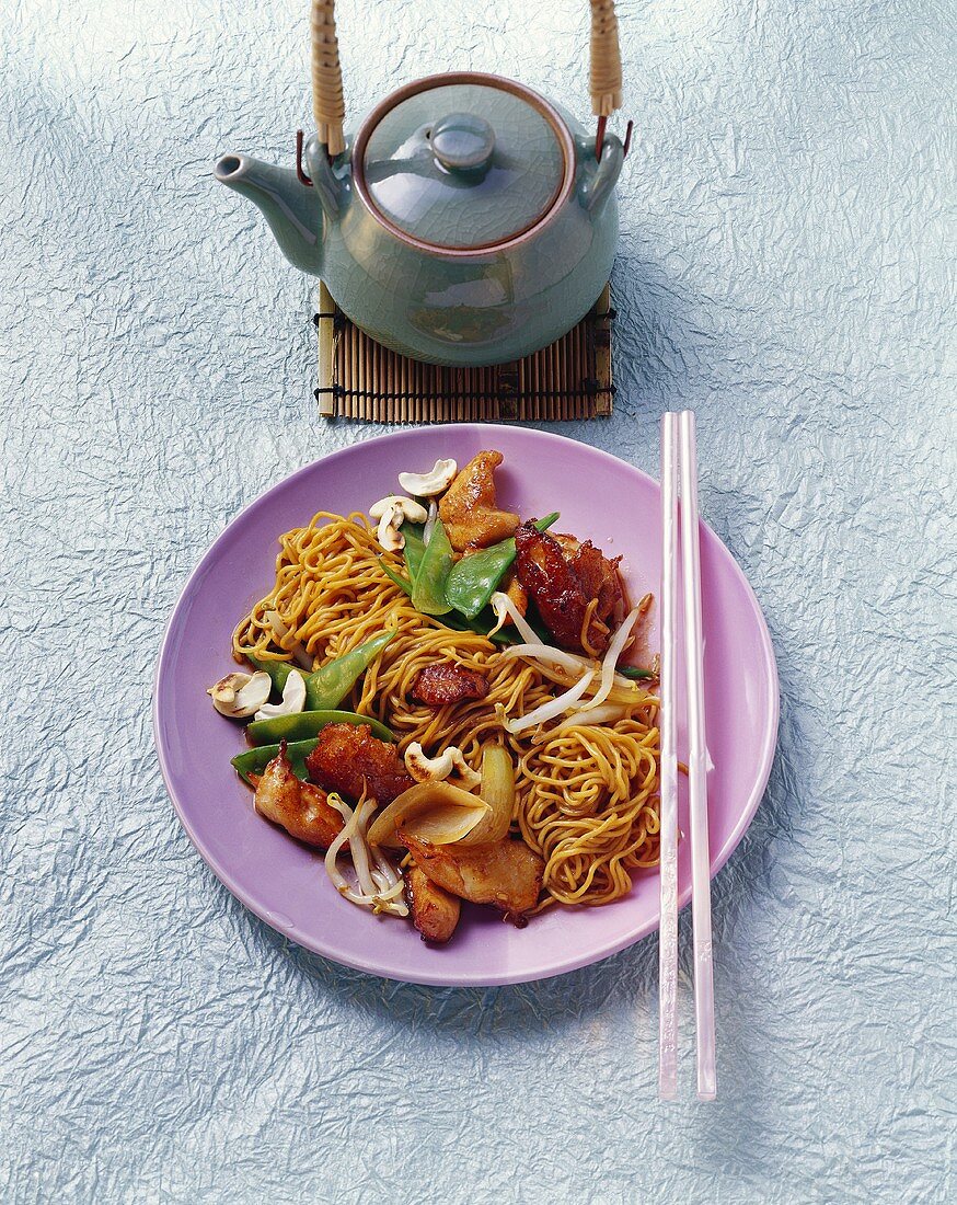 Pan-cooked chicken dish with nuts and fried noodles