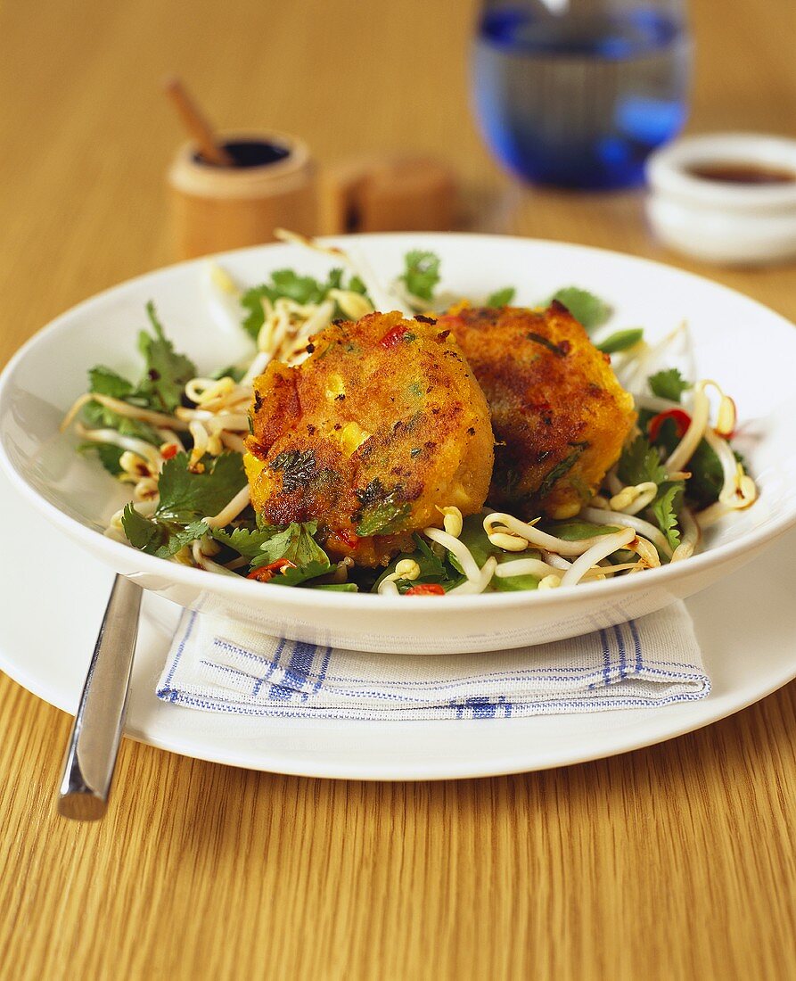 Fish cakes on herb and sprout salad