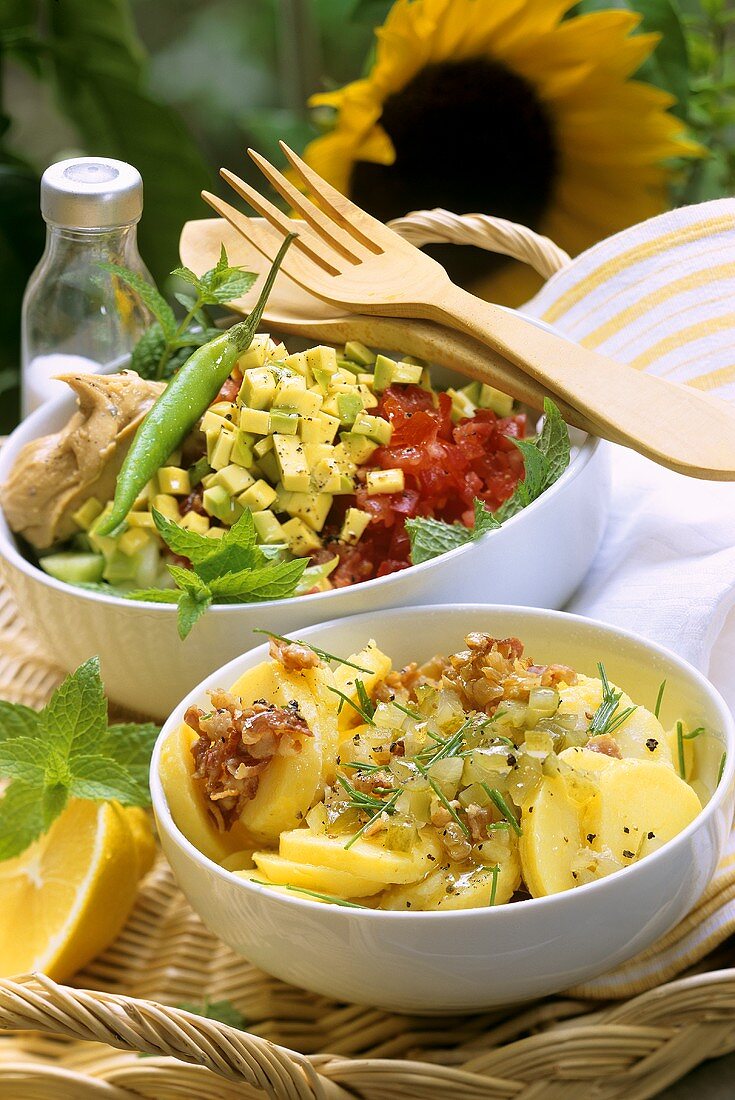 Potato salad and avocado and tomato salad with peanut cream