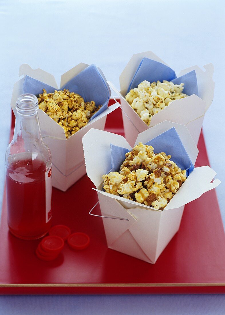 Popcorn in Take-Out-Behältern und eine Flasche Cranberrysaft