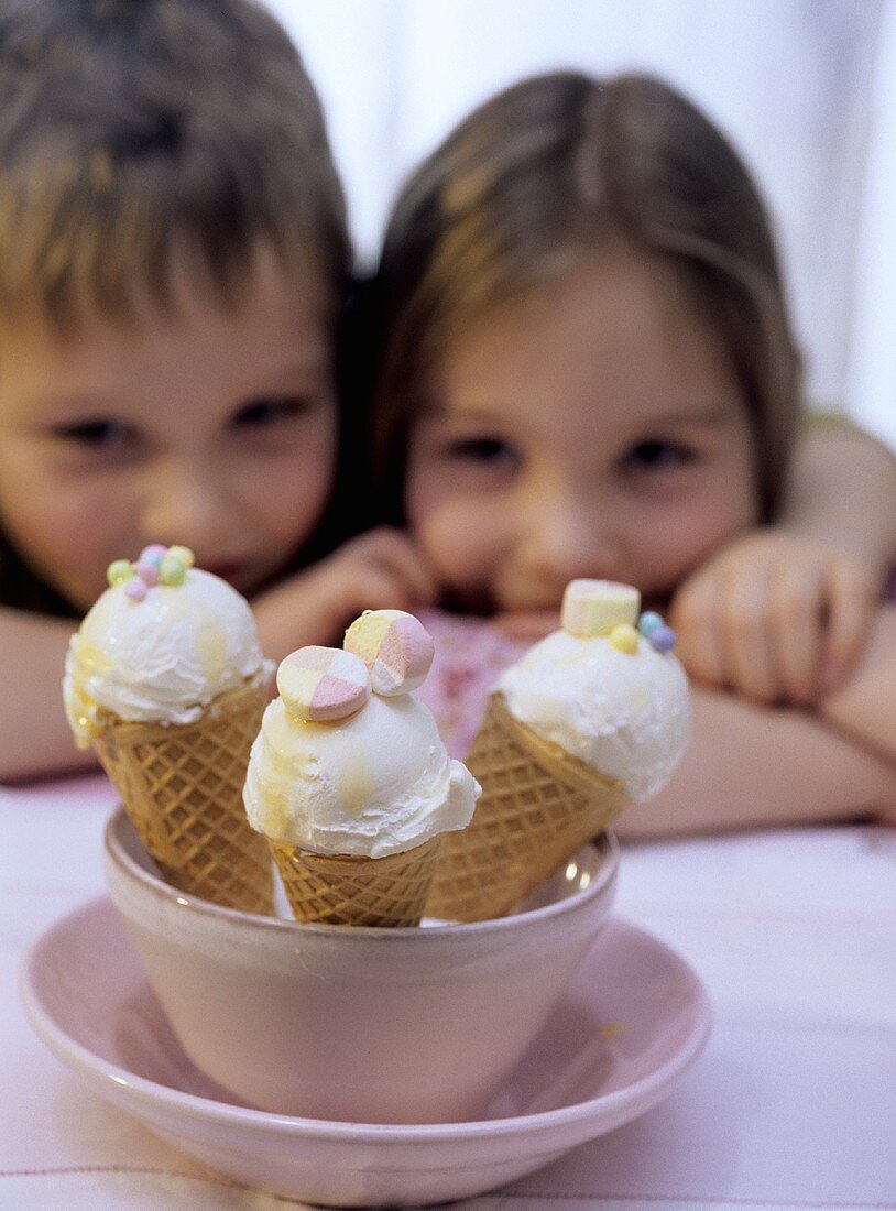 Three ice cream cones, a girl and a boy behind