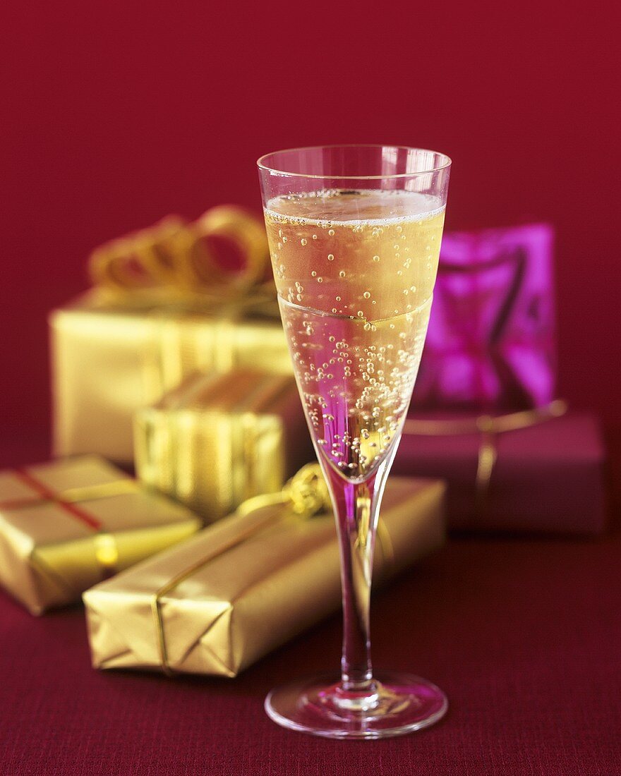 A glass of champagne and wrapped gifts