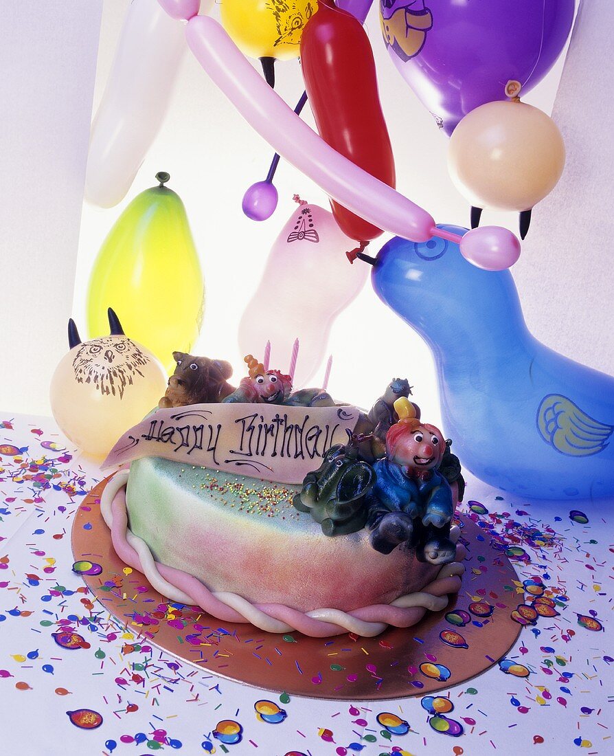 Geburtstagstorte mit drei Kerzen und Luftballons
