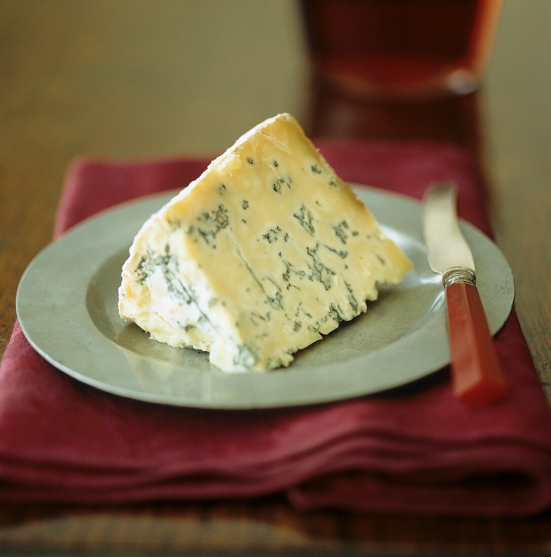 A piece of Stilton cheese with knife