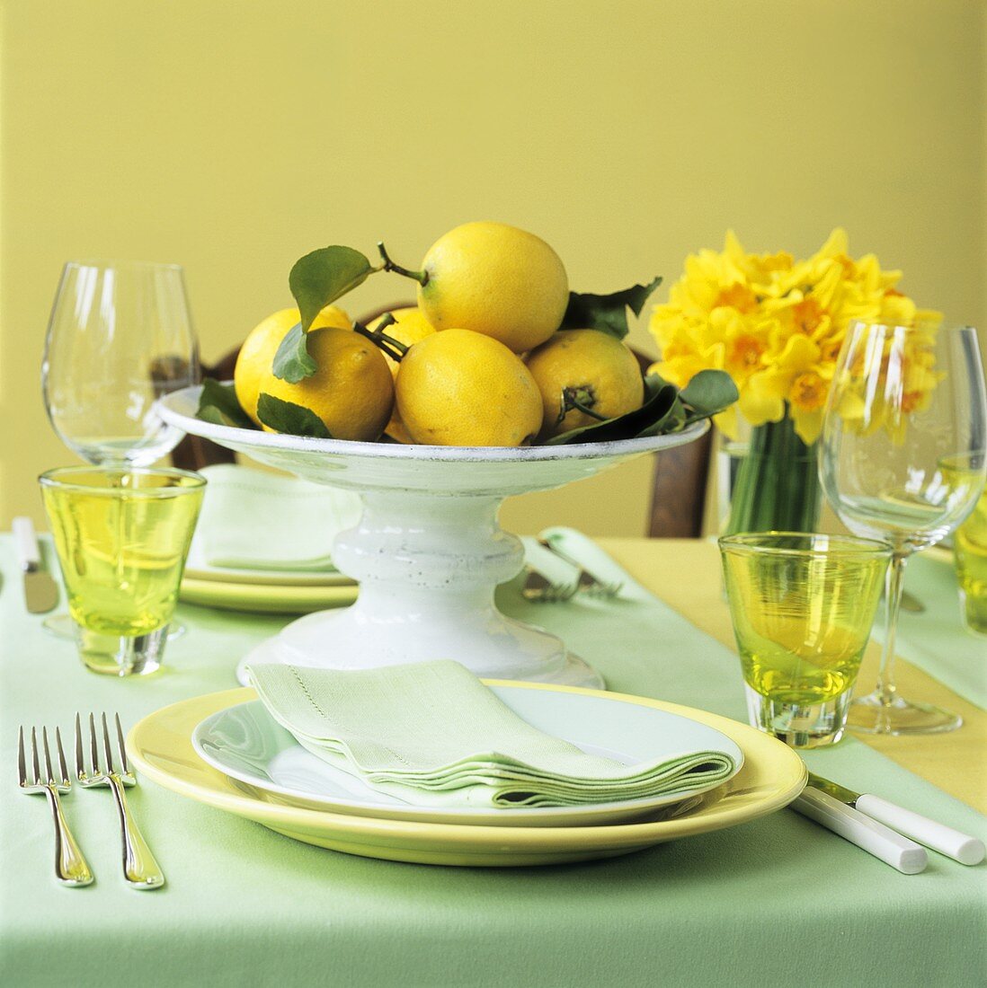 Bowl of lemons on table laid for two