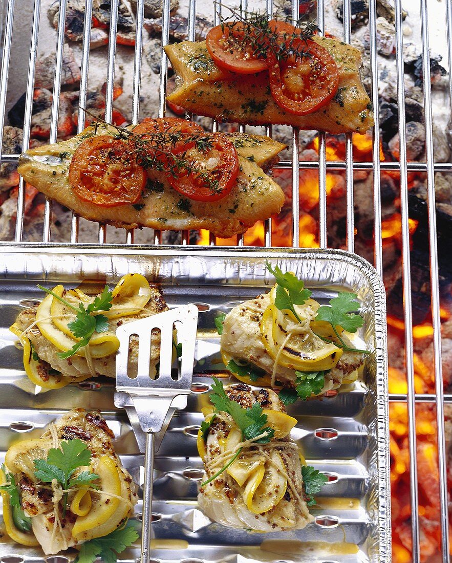 Fish fillet with tomatoes & fish parcels with lemons on grill