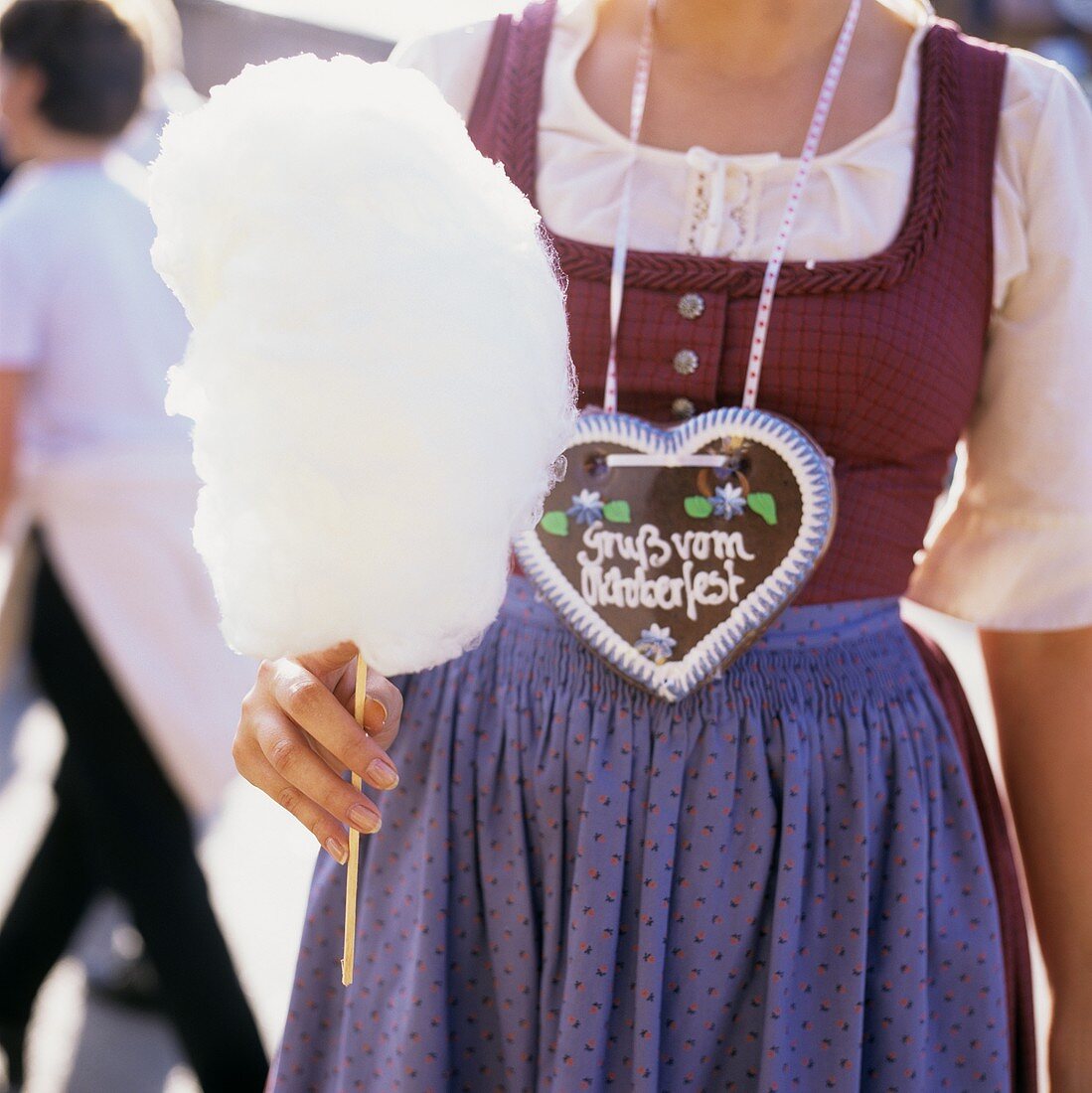 Frau mit Zuckerwatte und Lebkuchenherz am Oktoberfest