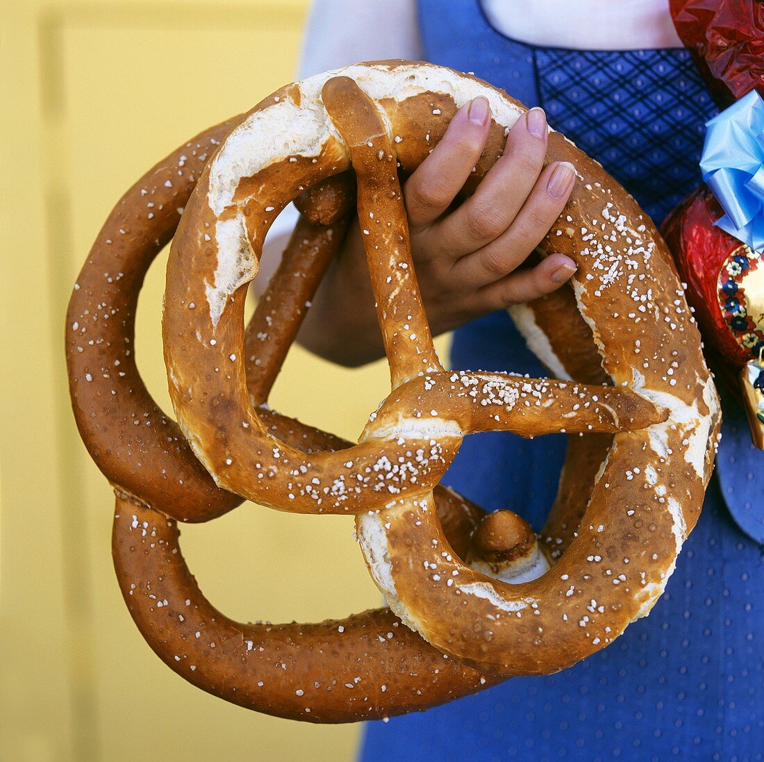 Frau hält zwei grosse Brezeln in der Hand