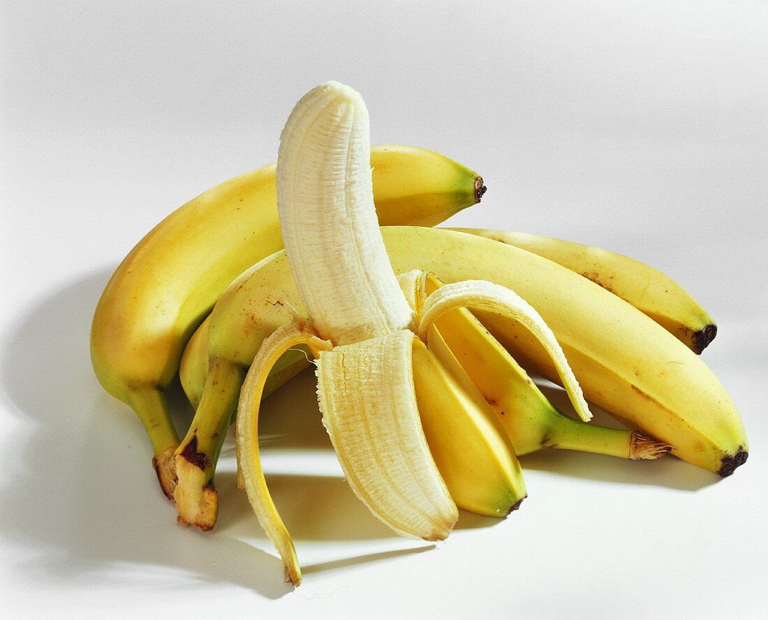 Bananen, eine halb geschält