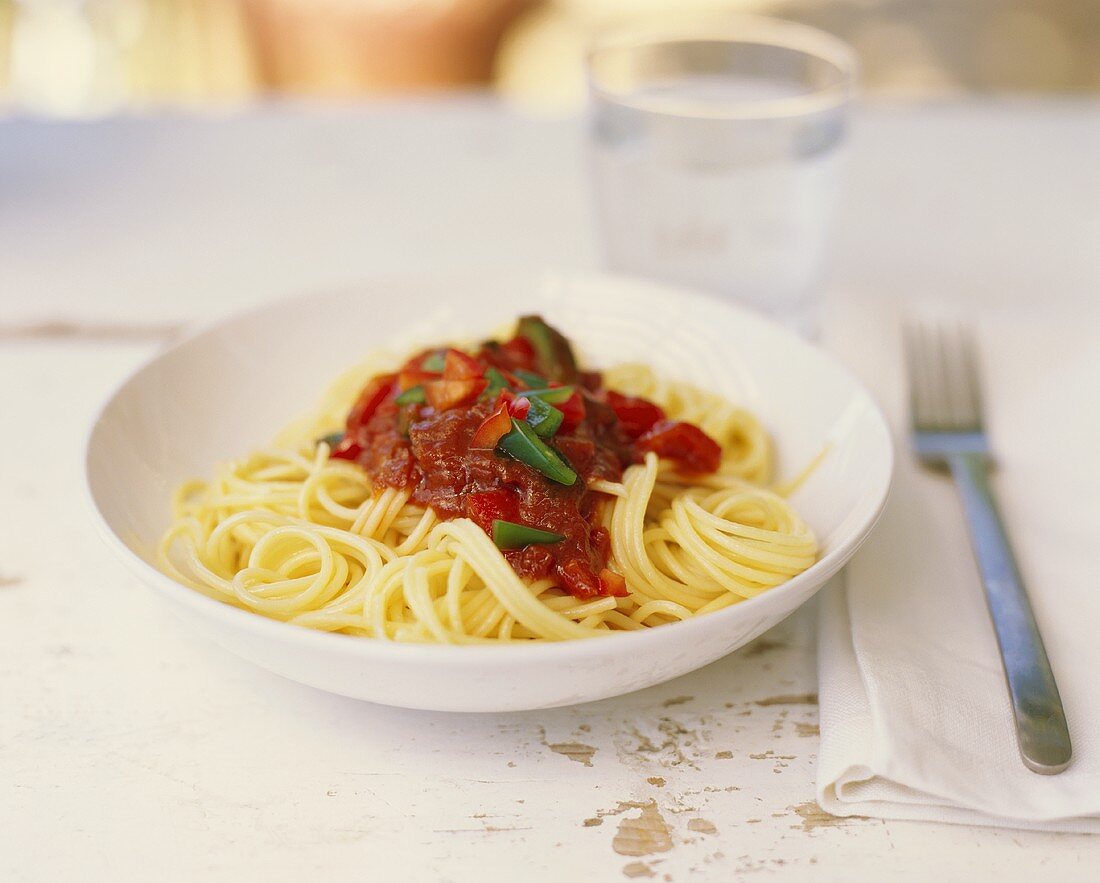 Spaghetti mit Tomatensauce und ein Glas Wasser