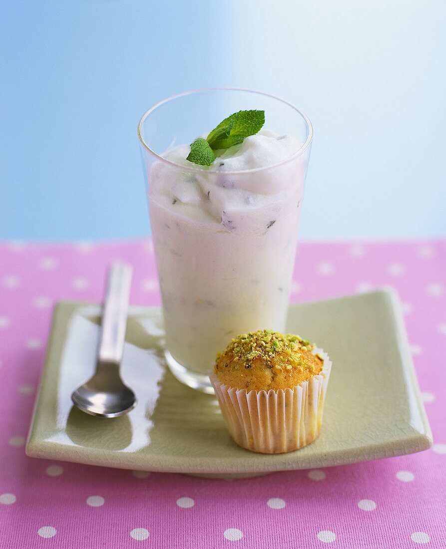 A glass of mint yoghurt with a pistachio bun