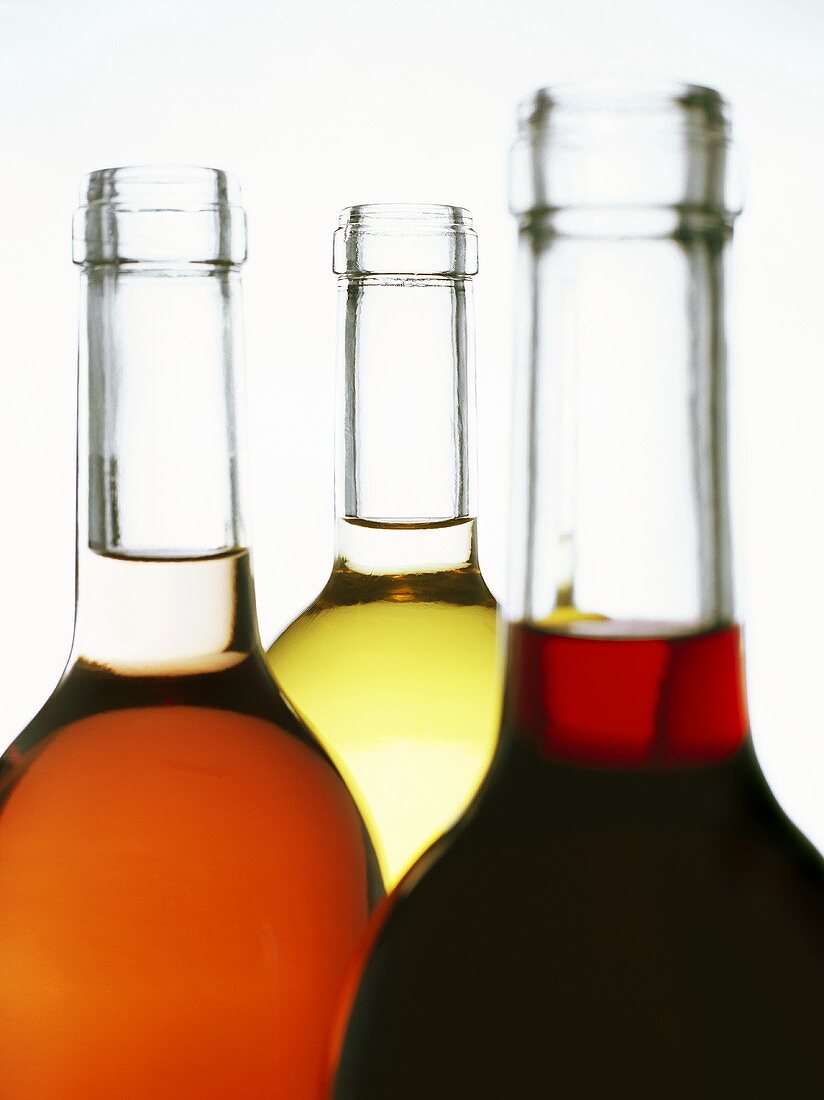 Eine Rotwein-, eine Rosé- und eine Weissweinflasche