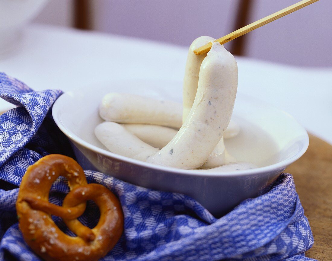 Weisswurst sausages in a dish with pretzels