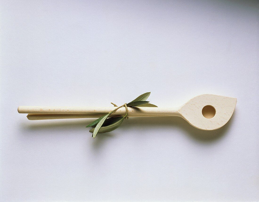 A kitchen spoon with olive leaves