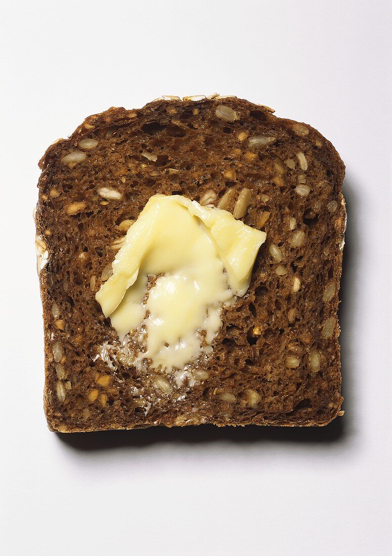 Ein Schwarzbrot mit Butter bestrichen