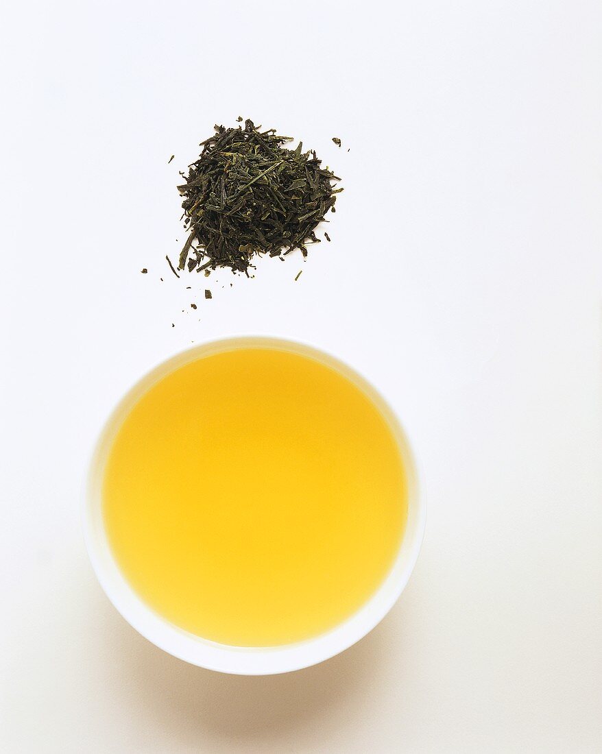 Bowl of green tea and green tea leaves
