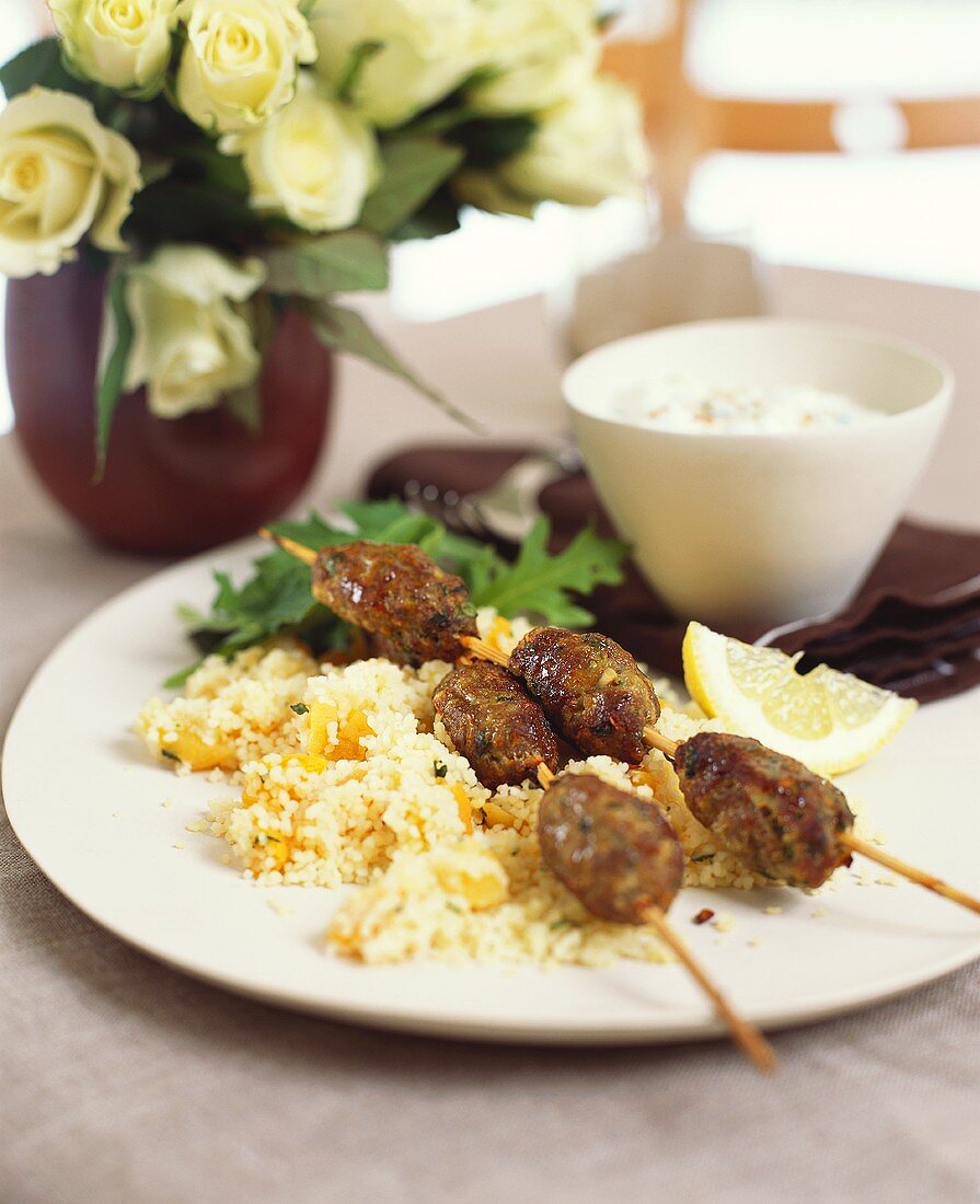 Cevapcici on sticks on couscous