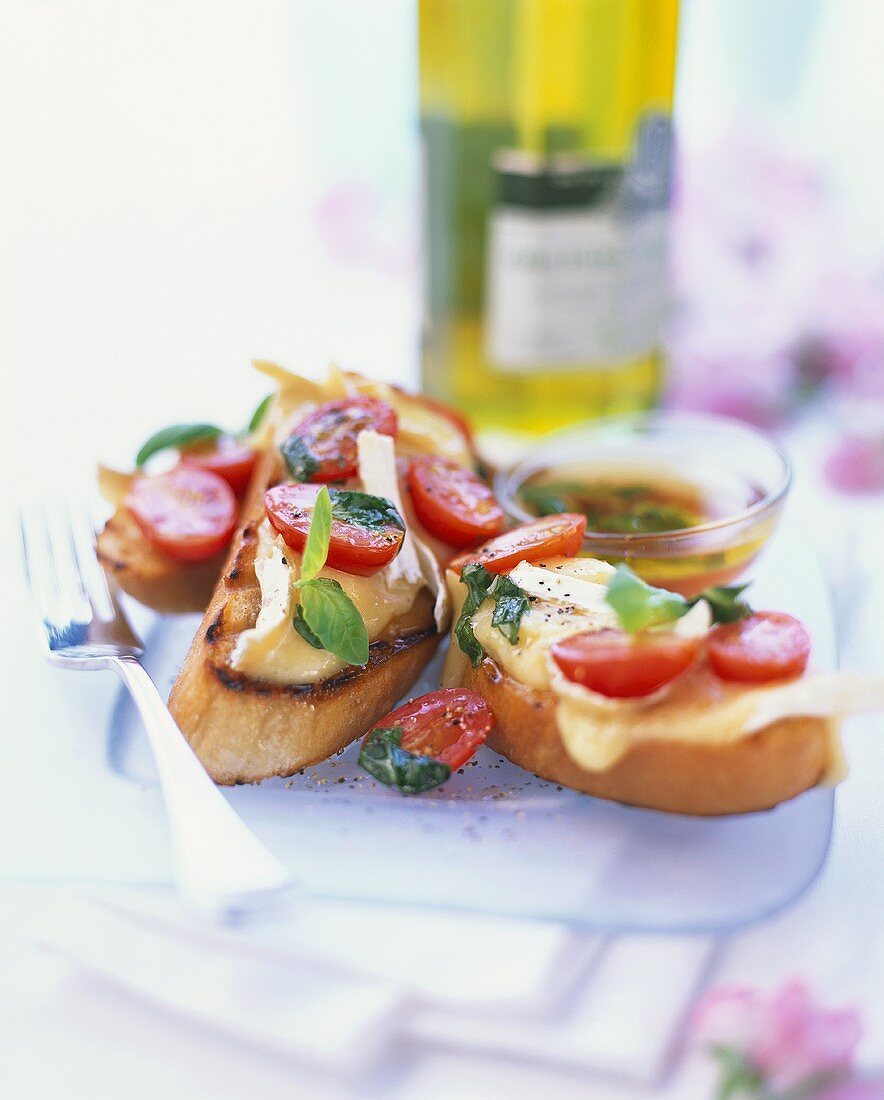 Geröstete Brote mit Camembert, Kirschtomaten und Basilikum