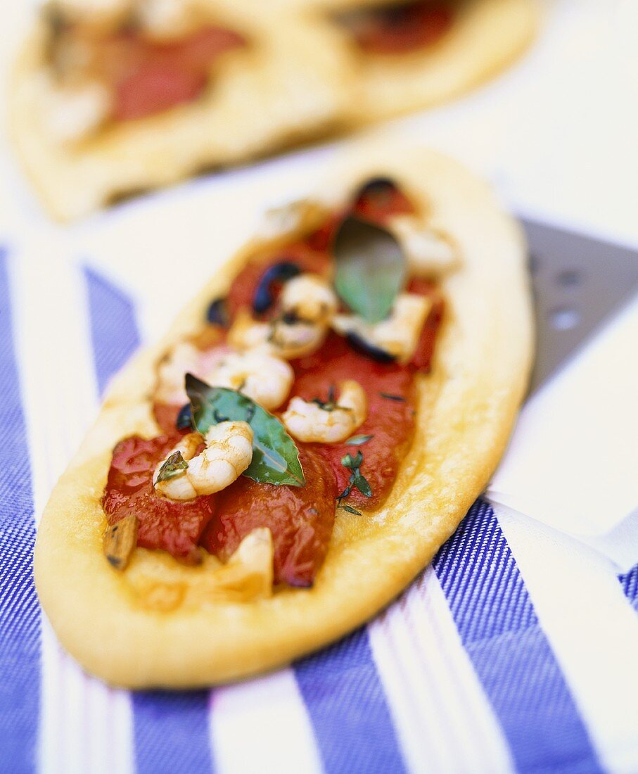 Mini-pizza with tomatoes, shrimps and basil