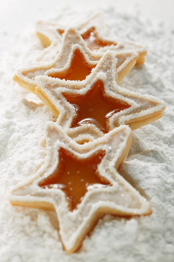 Star-shaped butter biscuits (jam biscuits) on icing sugar
