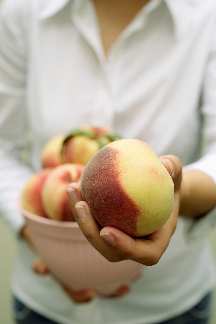 Hand holding a peach