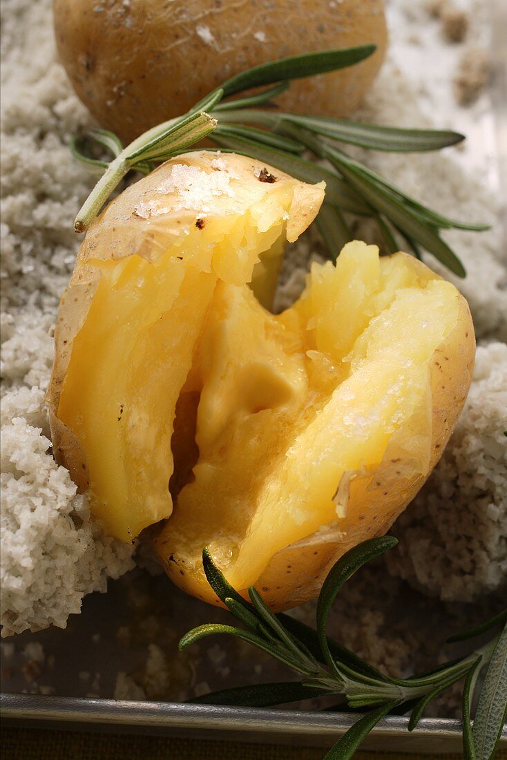 Aufgebrochene Ofenkartoffel in Salzkruste mit Rosmarin