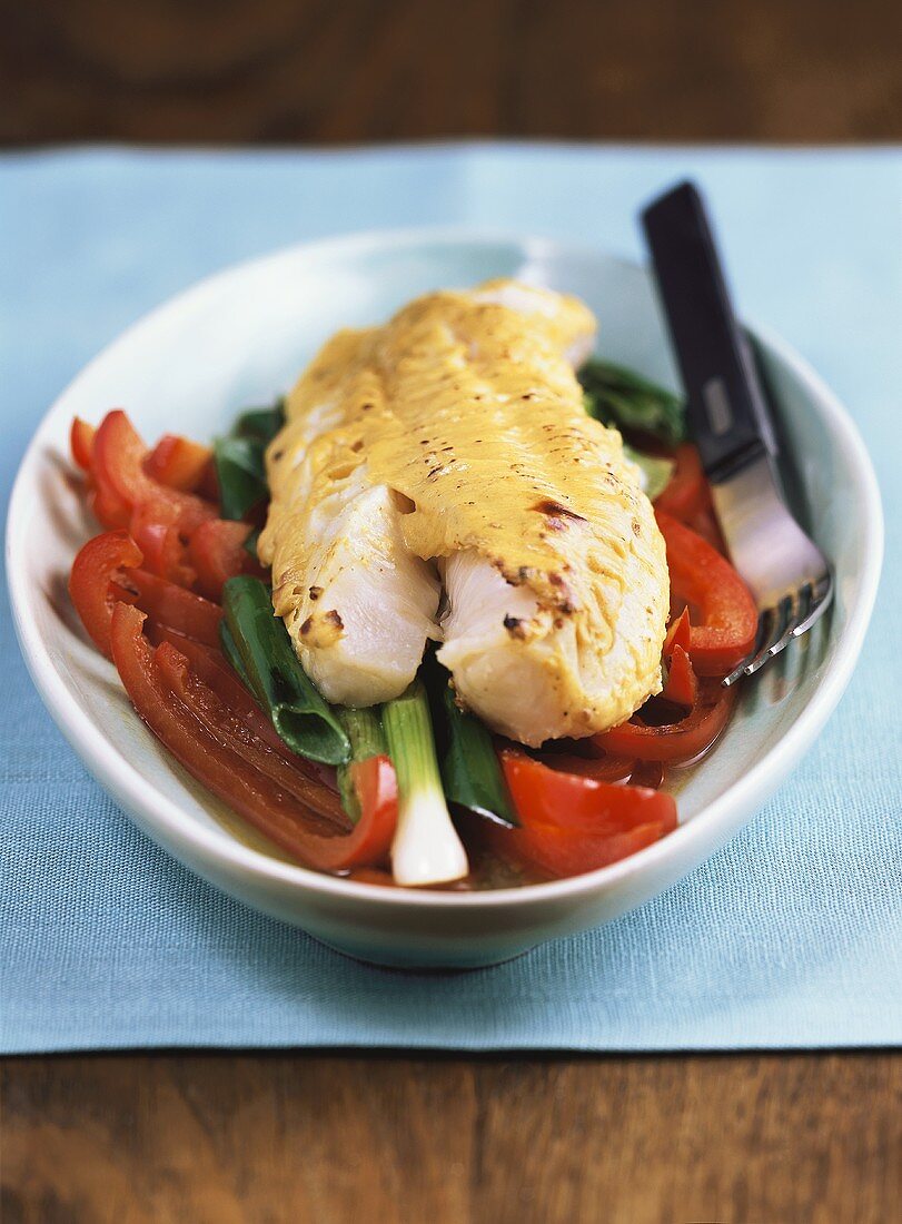 Cod with mustard sauce on peppers and onions