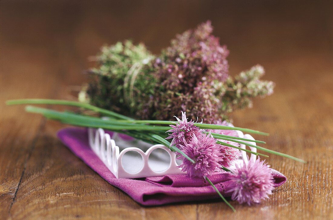 Chives with flowers, bunch of herbs behind