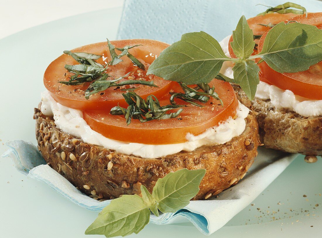 Geröstetes Vollkornbrötchen mit Frischkäse und Tomaten