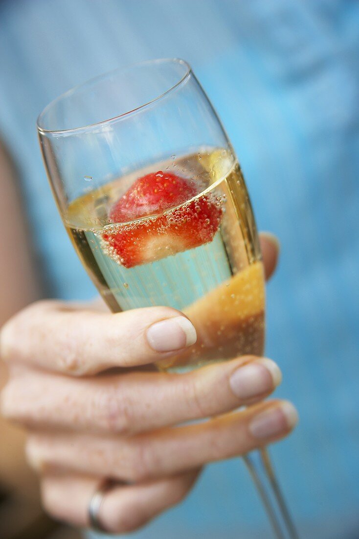 A glass of champagne with strawberry