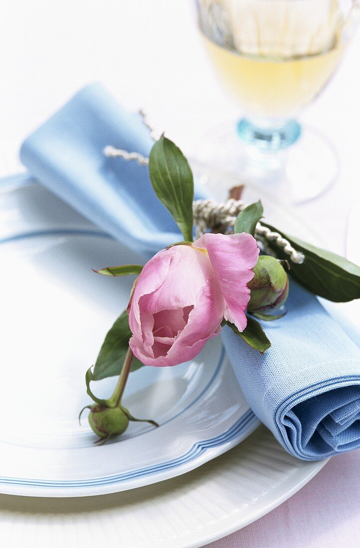 Place setting with fabric napkin and peony