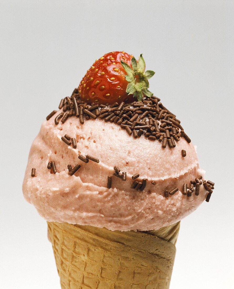 Strawberry ice cream with chocolate sprinkles in a cone