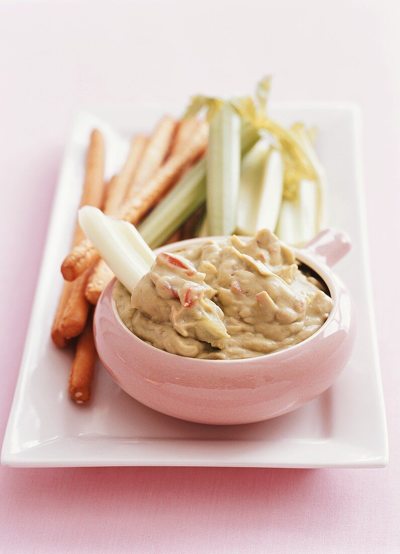 Guacamole mit Salzstangen und Staudensellerie