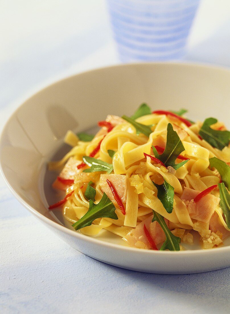 Ribbon pasta with turkey ham, rocket and chili peppers
