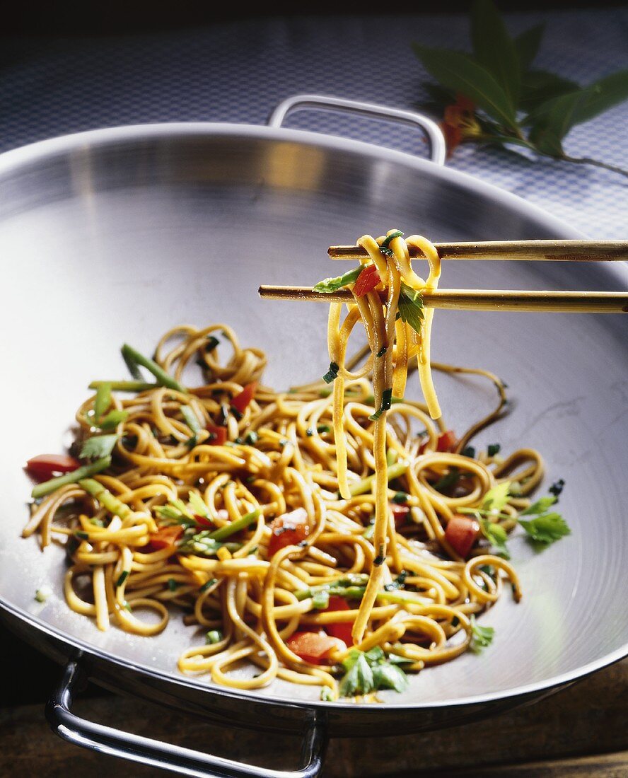 Asian noodles cooked in wok with asparagus and peppers