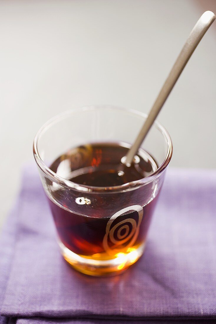 Maple syrup with spoon in glass