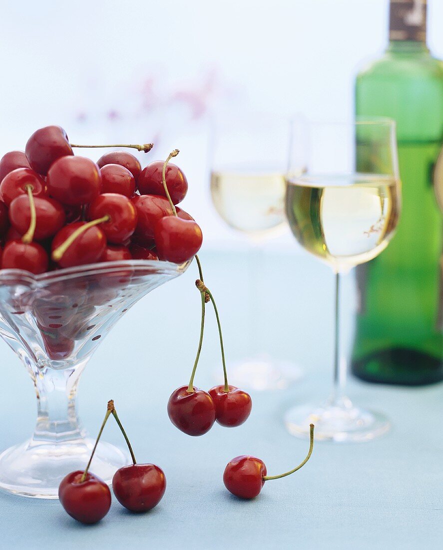 Bowl of cherries and two glasses of white wine