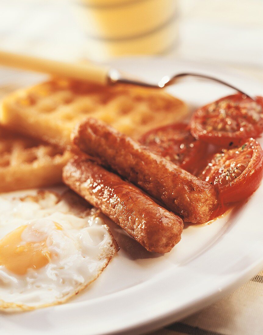 Englisches Frühstück mit Spiegelei, Würstchen und Tomaten