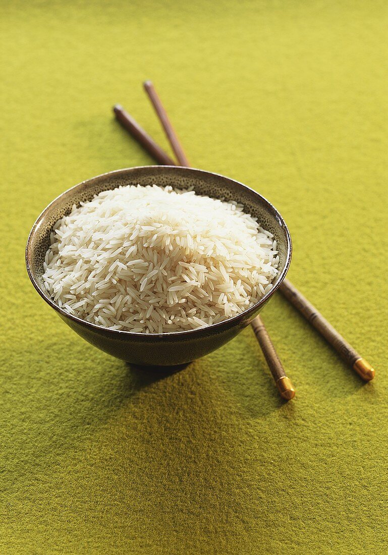 Bowl of long-grain rice and chopsticks