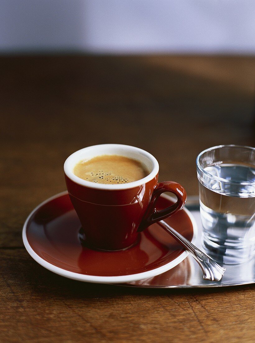 A cup of espresso and a glass of water