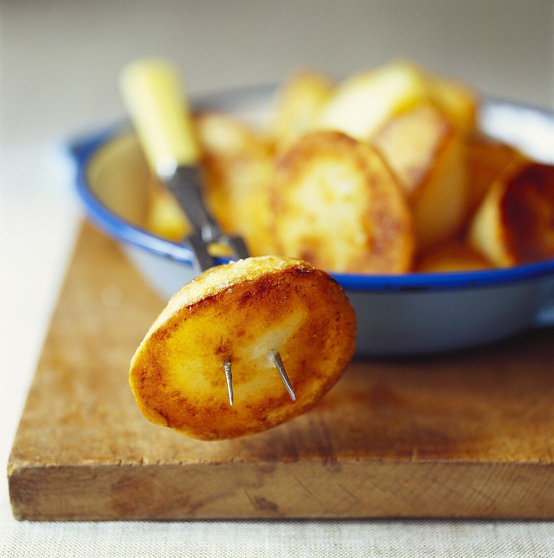 Roasted potatoes in a bowl and on fork